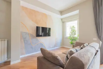 a living room with a couch and a tv on a wall at SuityRHome San Giovanni 11 in Rome