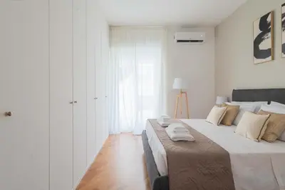 a white bedroom with a large bed with towels on it at SuityRHome San Giovanni 11 in Rome