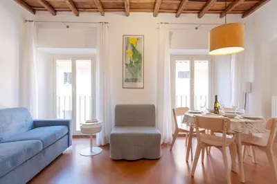 a living room with a blue couch and a table at Elegantis Josephine Suite - Elegance near Spanish Steps Trevi and Pantheon in Rome