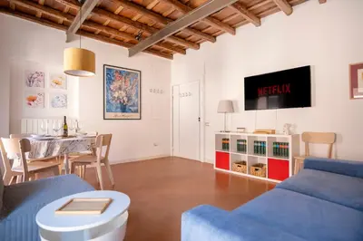 a living room with a blue couch and a table at Elegantis Josephine Suite - Elegance near Spanish Steps Trevi and Pantheon in Rome