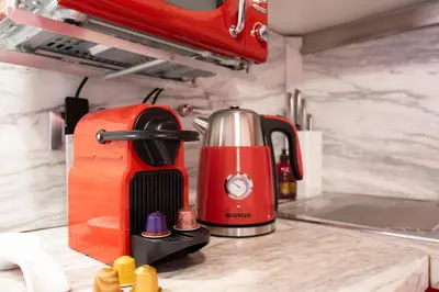 a red blender sitting on top of a kitchen counter at Elegantis Josephine Suite - Elegance near Spanish Steps Trevi and Pantheon in Rome