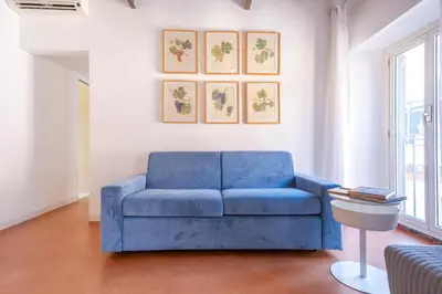 a blue couch sitting in a living room at Elegantis Josephine Suite - Elegance near Spanish Steps Trevi and Pantheon in Rome