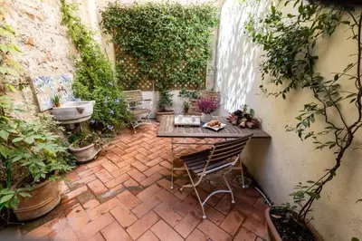 a patio with a table and chairs and a waterfall at Secret Garden Apt Colosseo - Homkeey Apartments in Rome
