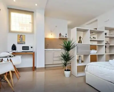 a living room with a bed and a kitchen at Secret Garden Apt Colosseo - Homkeey Apartments in Rome