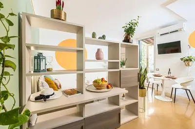 a living room with shelves and a dining room at Secret Garden Apt Colosseo - Homkeey Apartments in Rome