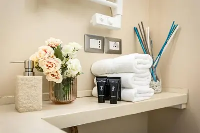 a shelf with a vase of flowers and towels at Secret Garden Apt Colosseo - Homkeey Apartments in Rome