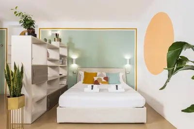 a bedroom with a white bed and a plant at Secret Garden Apt Colosseo - Homkeey Apartments in Rome