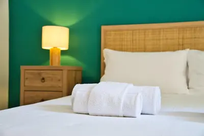 a bed with towels on it with a green wall at Little Dome - San Pietro in Rome