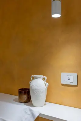 a white vase sitting on a table next to a lightswitch at Colosseum Essence - Homkeey Apartments in Rome