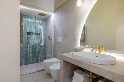 a bathroom with a sink and a toilet and a shower at Colosseum Essence - Homkeey Apartments in Rome
