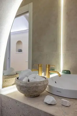 a bathroom with a bowl of rocks and a sink at Colosseum Essence - Homkeey Apartments in Rome