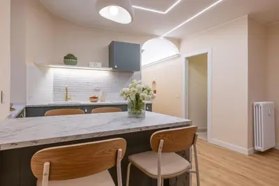 a kitchen with a counter with chairs and a counter top at Colosseum Essence - Homkeey Apartments in Rome