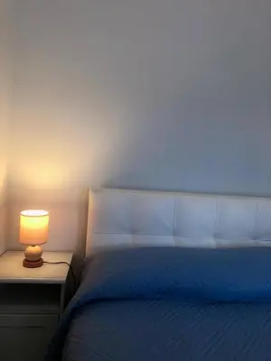 a bedroom with a bed with a lamp on a night stand at Trilocale con terrazza e garage in Rome