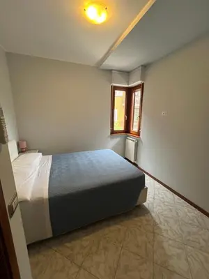 a bedroom with a bed and a window at Trilocale con terrazza e garage in Rome
