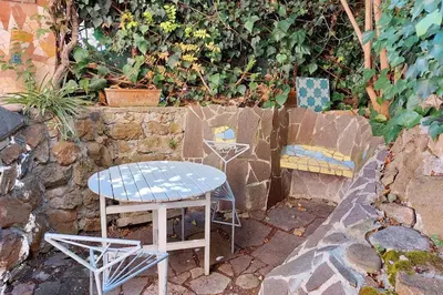 a table and chairs sitting next to a stone wall at Casa Gaudì in Rome