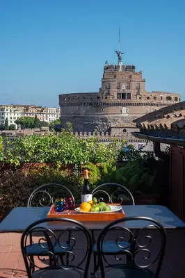 a table with a plate of fruit and a bottle of wine at The Perfect View- Angel's Castle' in Rome