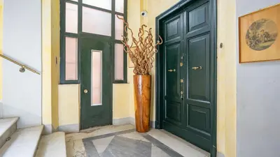 a green door with a plant in a vase next to it at La Casa d'Argento in Rome