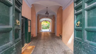 an empty hallway with green doors and an archway at La Casa d'Argento in Rome