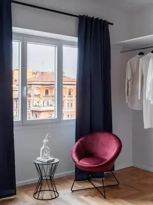 a red chair in a room with a window at Zen Trastevere Luxury Room - Zen 54 in Rome