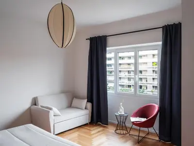 a living room with a couch and a chair and a window at Zen Trastevere Luxury Room - Zen 54 in Rome