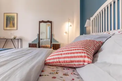 a bed with a red and white pillow on it at Domus Veneranda in Rome