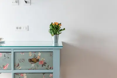 a blue dresser with a vase of flowers on top at Domus Veneranda in Rome