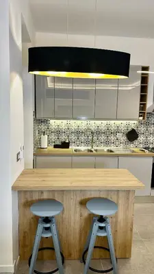 a kitchen with a wooden counter with two stools at AliHouse Apartment in Rome