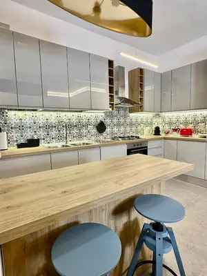 a kitchen with a wooden counter and a blue stool at AliHouse Apartment in Rome