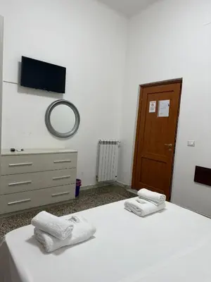a bedroom with two beds and a tv on the wall at Roma Belvedere Termini in Rome