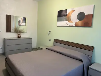 a bedroom with a bed and a dresser at Oasi di pace in Rome
