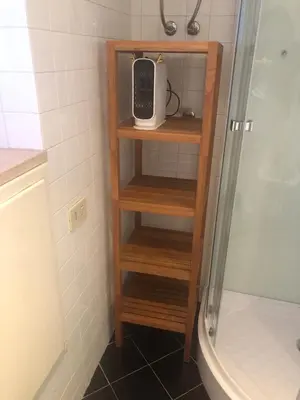 a wooden shelf in a bathroom next to a shower at Trastevere Mini-apartment in Rome