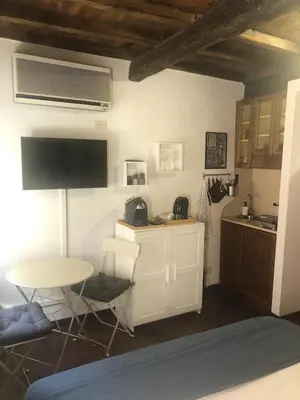 a living room with a table and a kitchen at Trastevere Mini-apartment in Rome