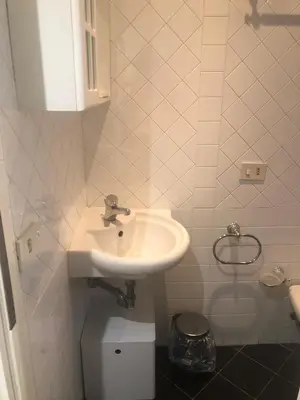 a white bathroom with a sink and a toilet at Trastevere Mini-apartment in Rome