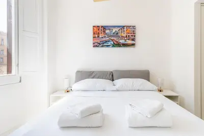 a white bedroom with a white bed with two white pillows at Maison Parlamento - Roma centro in Rome