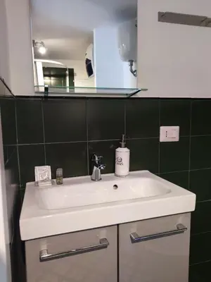 a bathroom with a white sink and a mirror at Monti loft al Colosseo in Rome