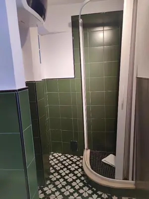 a bathroom with a shower with green tiles at Monti loft al Colosseo in Rome