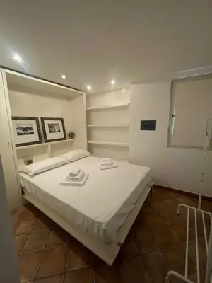 a bedroom with a white bed with towels on it at Monti loft al Colosseo in Rome