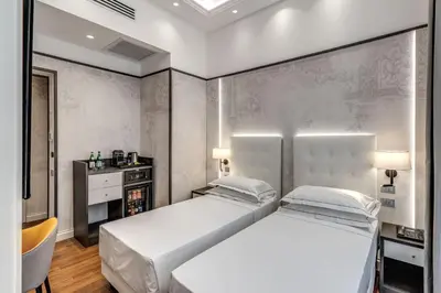 a bedroom with two white beds and a tv at The Spotlight Boutique Hotel in Rome