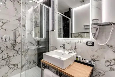 a white bathroom with a sink and a shower at The Spotlight Boutique Hotel in Rome