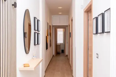 a hallway in a house with white walls and a mirror at Angelico living Rome in Rome
