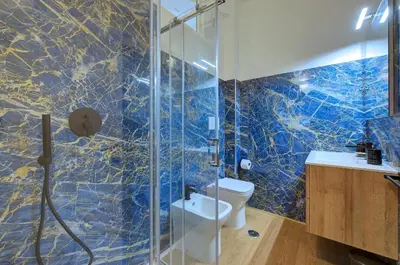 a bedroom with a large white bed with blue accents at Cinema Design Home San Giovanni in Rome