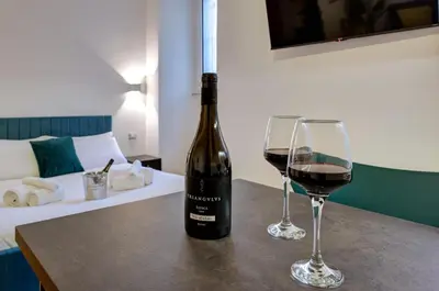 a bottle of wine and two glasses on a table at Cinema Design Home San Giovanni in Rome