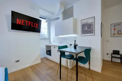 a kitchen with a table and chairs in a room at Cinema Design Home San Giovanni in Rome
