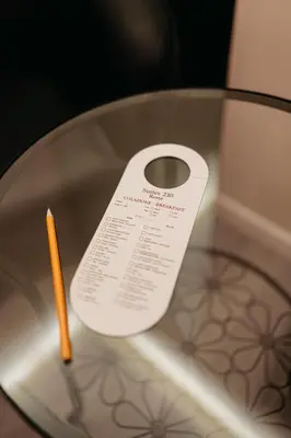 a piece of paper on a glass table with a pencil at Room 230 Roma Luxury Suites in Rome