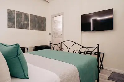 a bedroom with a bed and a flat screen tv at Room 230 Roma Luxury Suites in Rome