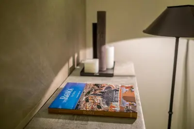 a book sitting on a table next to a lamp at Room 230 Roma Luxury Suites in Rome