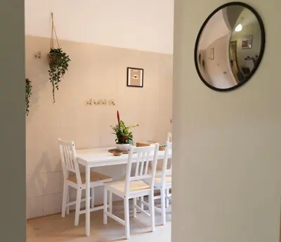 a white dining room table with white chairs and a mirror at Annmarie House, Vaticano - Cipro in Rome