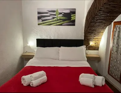 a bedroom with a bed with two towels on it at Arco acetari-Il medio evo nel cuore di roma in Rome