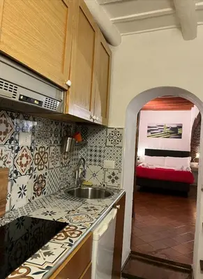 a kitchen with a sink and a room with a bed at Arco acetari-Il medio evo nel cuore di roma in Rome