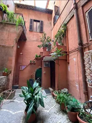 an alley with a building with potted plants on it at Arco acetari-Il medio evo nel cuore di roma in Rome